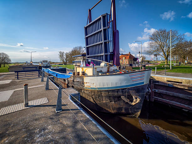 Old barge is passing through a drawbridge lock in Zeedijk, Nijkerk, Gelderland, Netherlands