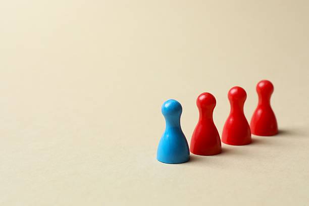 istock Group of colored pawns on the table. Concept of unity 2253376963