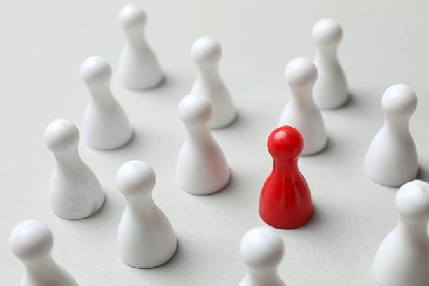 istock Group of colored pawns on the table. Concept of unity 2253376969