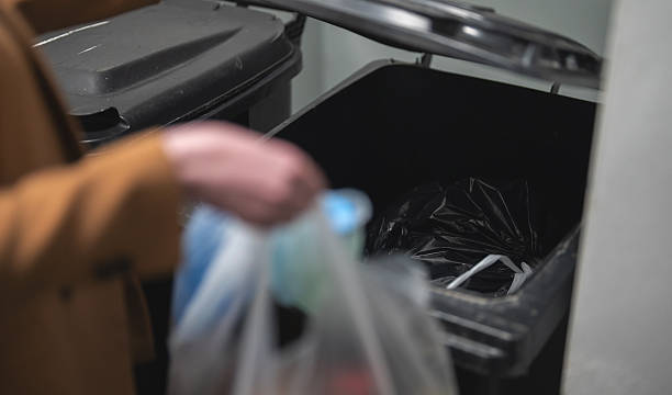 istock Woman throwing away garbage into trash bin. 2253377184