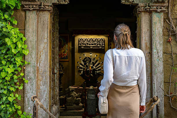 A girl tourist walks through the ancient stone shrines of the Jageshwar Temple complex in Uttarakhand, India. Surrounded by centuries-old Shiva temples and tall deodar forests, the scene reflects spiritual travel, heritage tourism, and sacred architecture in the Indian Himalayas. The image highlights cultural exploration, pilgrimage, and the historic religious landscape of Jageshwar Dham.