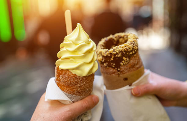 istock Two traditional Czech trdelnik pastries in hands. 2253377240