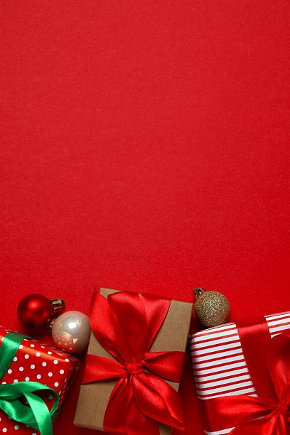 istock Beautiful Christmas gift boxes tied with bows and decorations on color background 2253377367