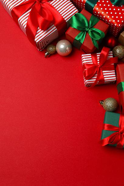 istock Beautiful Christmas gift boxes tied with bows and decorations on color background 2253377385