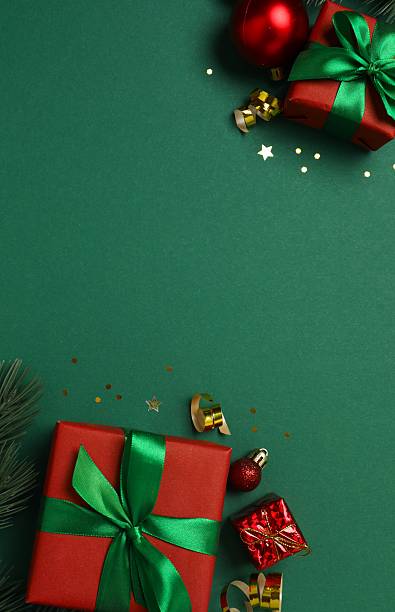 istock Beautiful Christmas gift boxes tied with bows and decorations on color background 2253377405