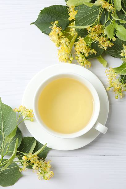 istock Green tea with fragrant linden in white cup on gray background 2253378191