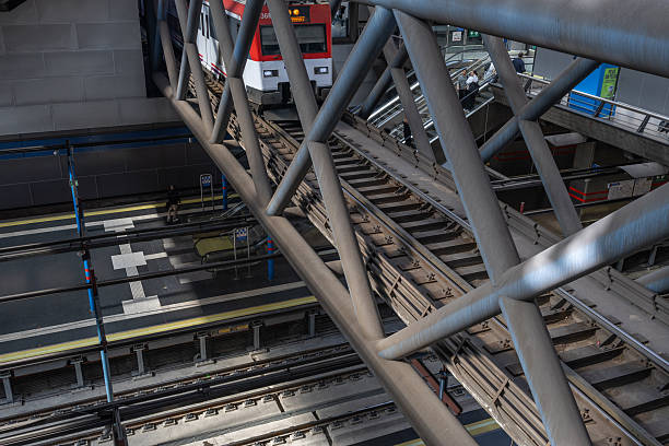 Príncipe pío metro and train station. Madrid. Spain. Looking down at a train arriving at a modern subway station with tracks, platforms, and escalators