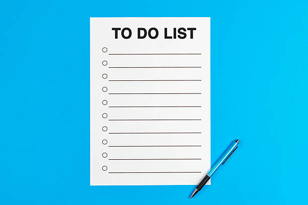 istock To do list, text and list on a page, and one pen on blue background. 2253383913