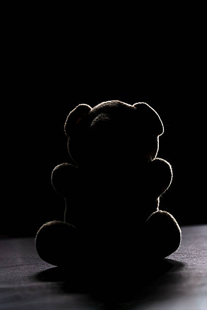 istock Teddy Bear Silhouette in Dark Minimalist Setting 2253384533