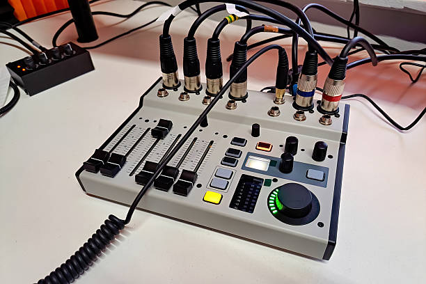 istock Compact USB audio mixer with faders, buttons, and XLR cables on studio desk 2253387415