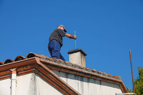 istock A person works on a chimney atop a house 2253388416