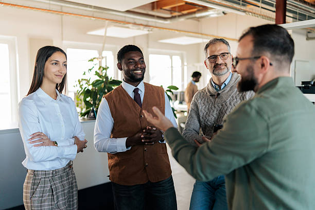 istock Colleagues Standing and Discussing Work in a Modern Office 2253388762