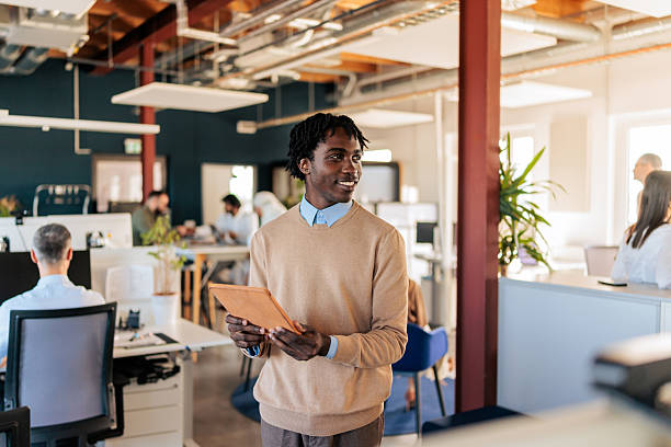 istock Smiling Businessman Holding a Tablet in a Modern Office 2253389073