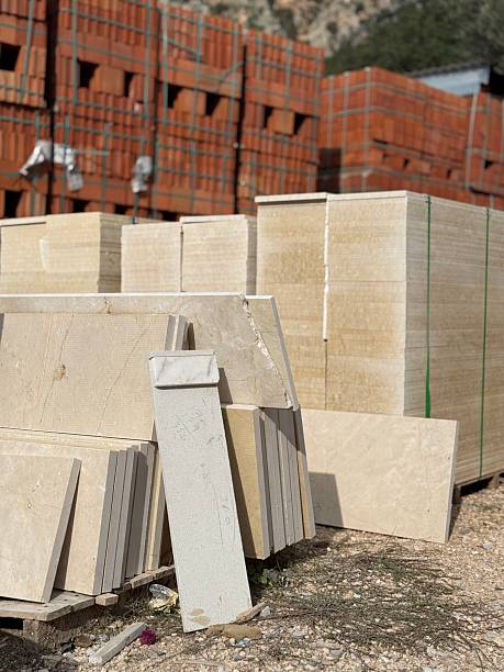 istock Construction materials stacked outdoors with piles of bricks and stone slabs in the background 2253393213