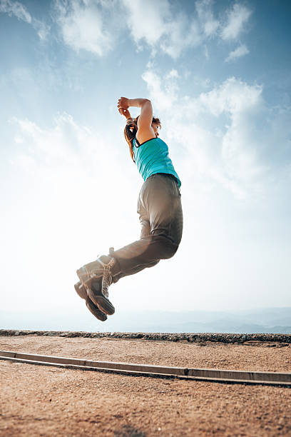 Full Length Portrait Of Woman Wearing Kangoo Jump Shoes Standing Outdoors
