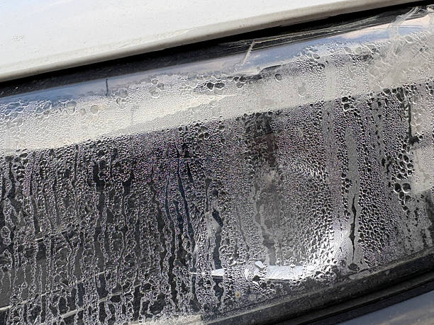 van headlight closeup with grime, textured plastic grille and lens showing dust and residue, workshop atmosphere, suggests maintenance and fleet service, useful for automotive repair and commercial