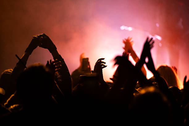istock Audience cheering at concert in a club 2253400021