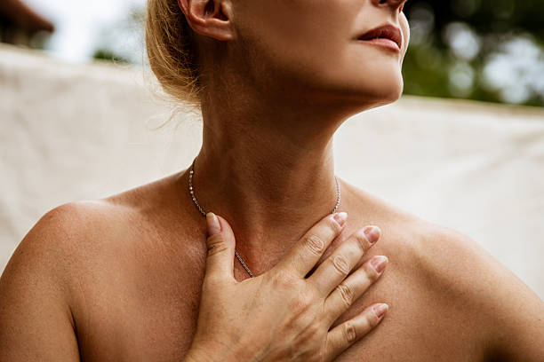 Closeup shirtless Woman with hand on Thyroid gland on her throat, Neck wrinkles, beauty, health care concept