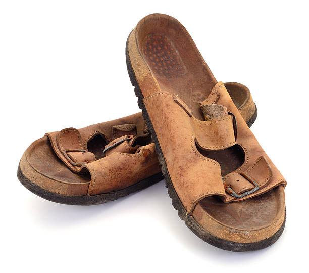 istock Old worn leather sandals isolated on white 2253400274