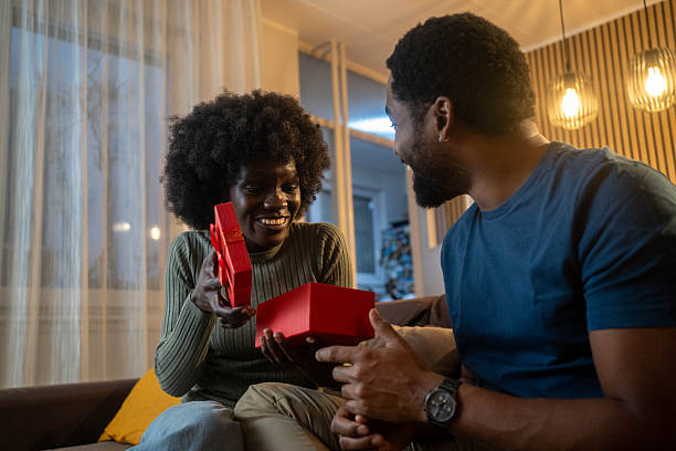 istock Romantic couple at home. Men giving a present to his girlfriend. 2253400366