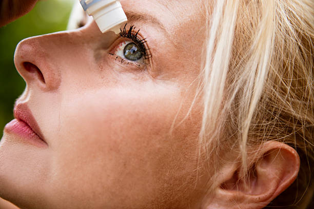 Senior man using eye drops.
