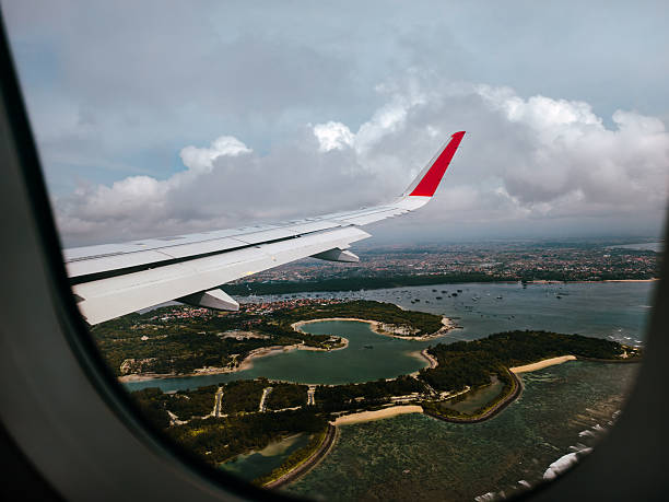 Airplane wings as they fly overhead. Natural landscape from the plane.