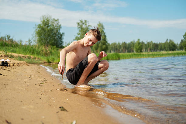 Boy Playing by the Water's Edge on a Sunny Day