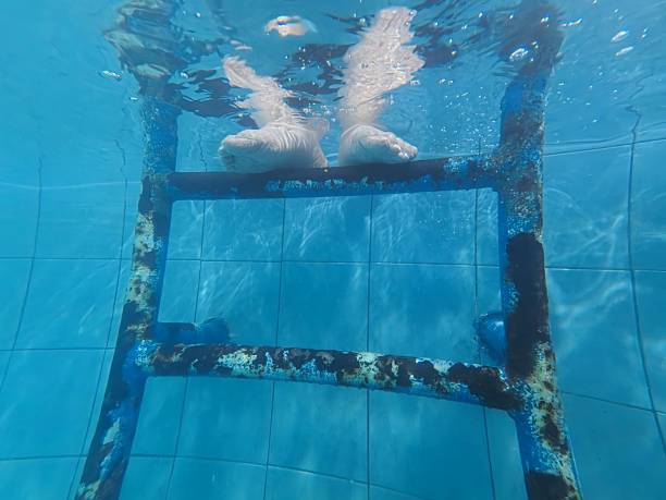 High angle view of unrecognizable senior Caucasian woman, relaxing in the swimming pool, at the spa center