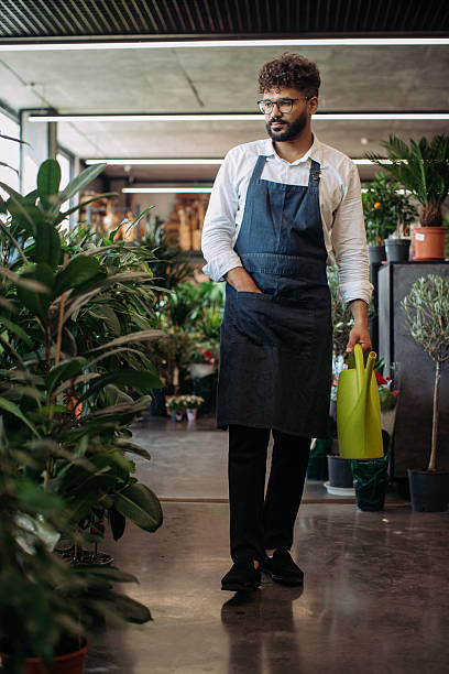 istock Florist caring for plants in flower shop 2253408287