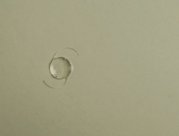 A close-up view of a water droplet on a light-colored surface, showcasing its round shape and reflections