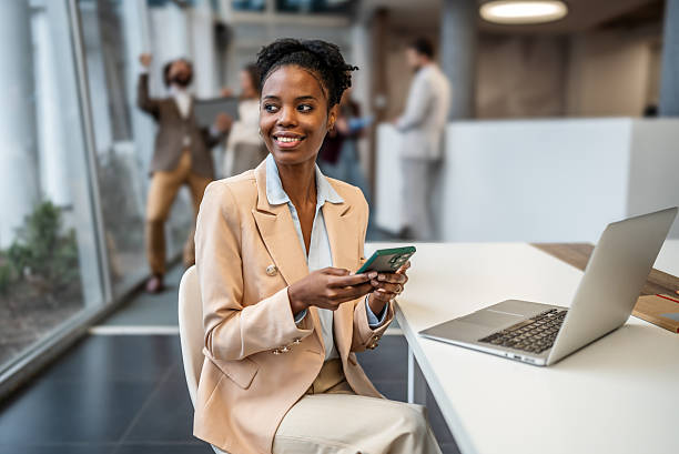istock Happy black businesswoman using smartphone in modern office 2253411060