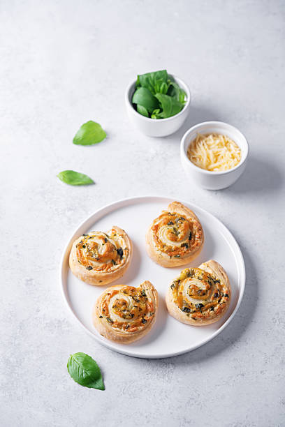 istock Basil garlic cheese roll cake pinwheel in a plate on a white isolated background 2253418552
