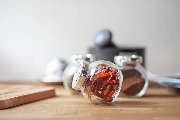 This is a close up of the hand of a woman shopping at the Saturday Farmer’s Market holding up a spice jar.