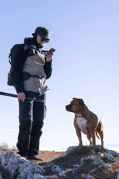 istock Man and dog standing on the mountain peak 2253427799