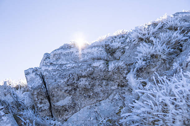Frozen cliff with frozen grass and sun beam above