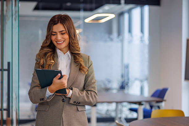istock Professional businesswoman smiling, using digital tablet in modern corporate office, planning successful business strategy 2253431895