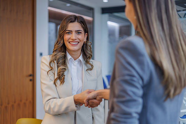 istock Smiling businesswoman making a handshake, sealing a prosperous partnership with a client in a modern office 2253434331