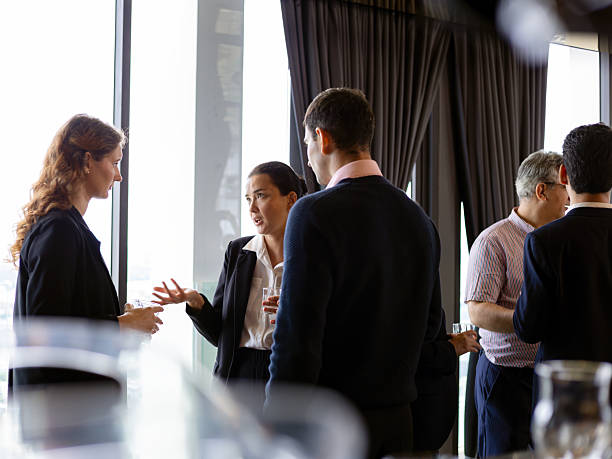 istock Business professionals having conversations and networking during a corporate event in a modern office setting, highlighting communication, teamwork, and professional interaction 2253435019