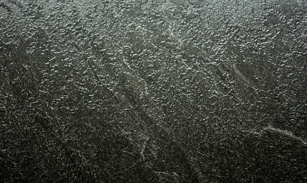 istock Black granite, natural stone surface close-up with traces of rough processing. 2253435630