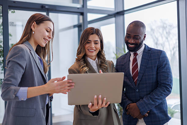 istock Diverse business professionals collaborating on a laptop, sharing ideas in a modern office environment, planning strategy for success 2253435697