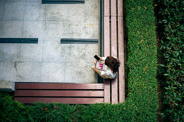 istock Professional Woman Analyzing Data and Managing Finances on Tablet and Smartphone Outdoors 2253436647
