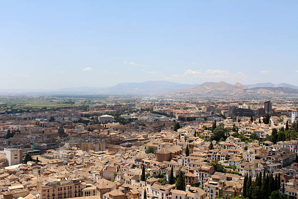 Smoke in the field (wheat) and Granada Cathedral with mountain Landscape from Alhambra  Granada, Spain, July 2024