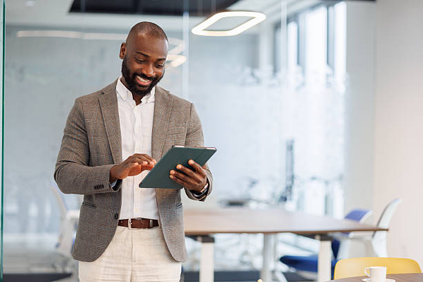 istock Smiling adult man using digital tablet, engaging with technology in a modern office environment 2253438226