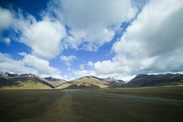 The blue sky white clouds and grassland snow mountain landscape