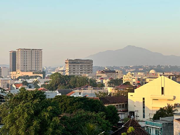 Tuban, East Java, Indonesia - July 10, 2025: Downtown Tuban as seen on higher ground with Mount Willis as the backdrop