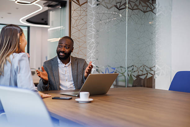 istock Diverse business professionals having a conversation in a modern office, collaborating on a project or discussing strategy 2253440039