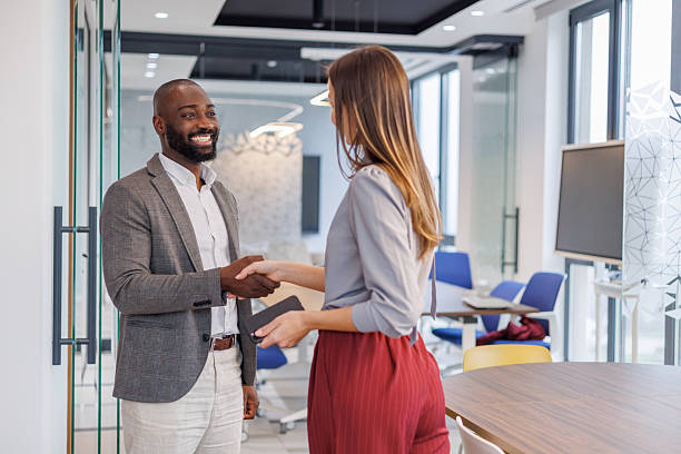istock Diverse business people shaking hands in a modern office, celebrating a partnership agreement 2253440573