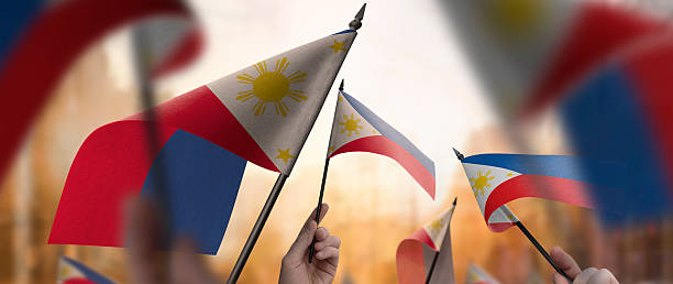 istock Philippines flags in their hands on a blurred urban background 2253441316