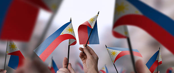 istock Philippines flags in their hands on a blurred urban background 2253441325