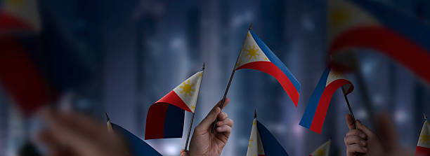 istock Philippines flags in their hands on a blurred urban background 2253441352